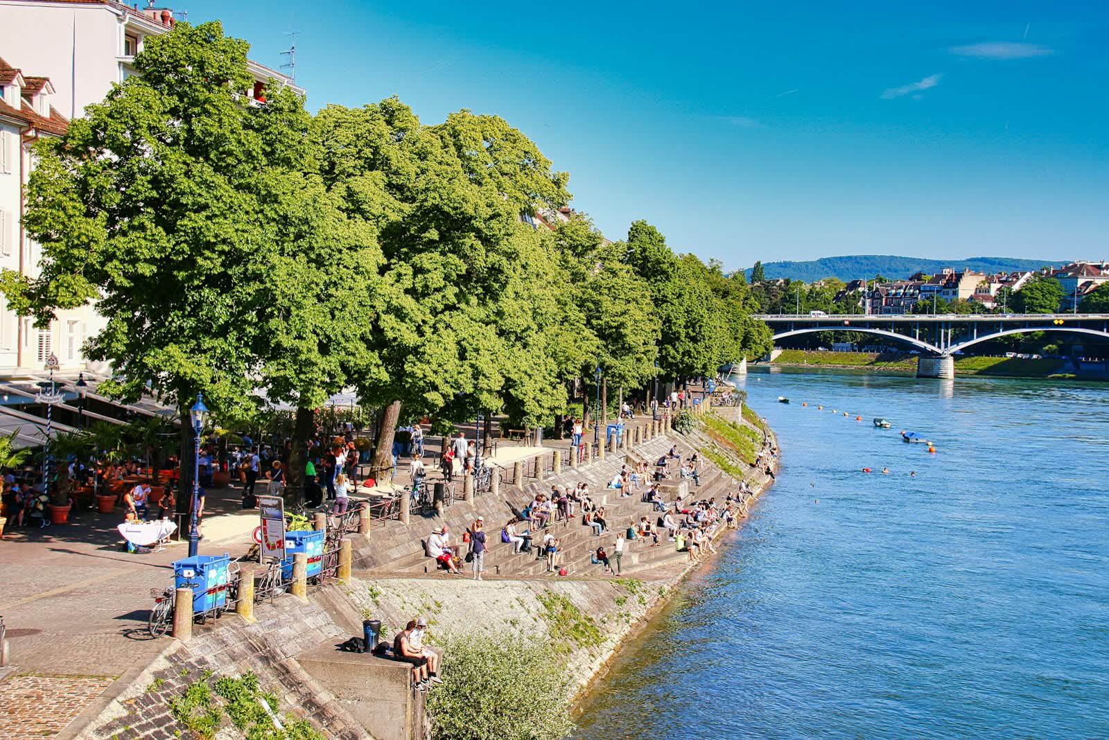 People on the Rhine riverbank in Basel on a sunny day